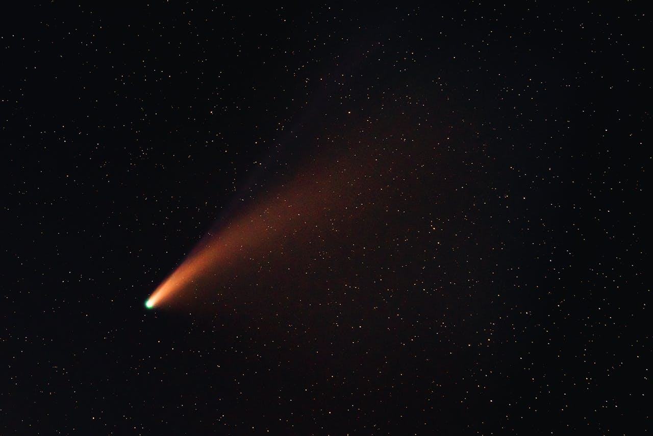 A comet with a red tail falling through space