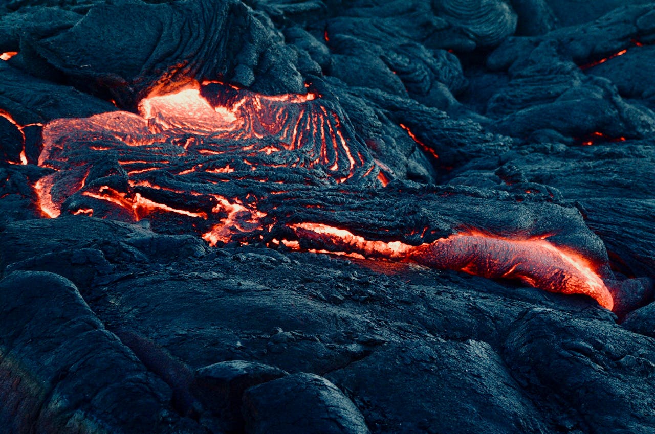 A floe of lava, mostly black but with glowing orange and yellow cracking through the surface